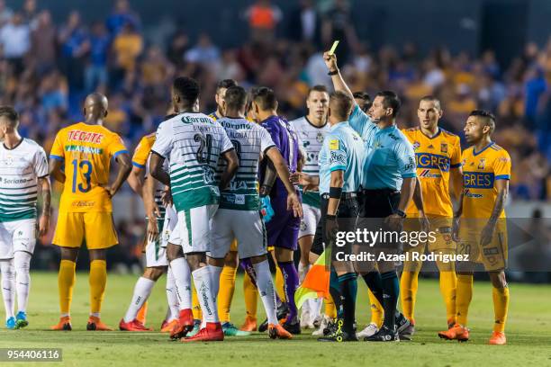 Referee Diego Montano gives a yellow card to Djaniny Tavares of Santos during the quarter finals first leg match between Tigres UANL and Santos...