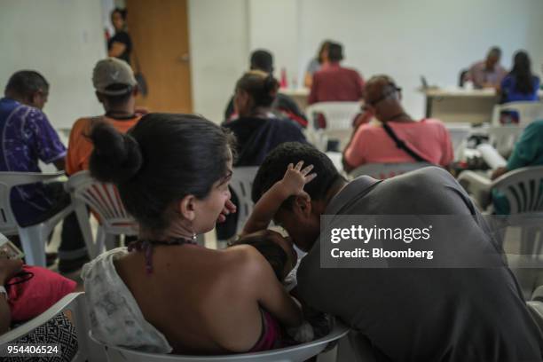 Young Venezuelan family waits for registration at the federal police headquarters in Boa Vista, Rondonia state, Brazil, on Thursday, May 3, 2018....