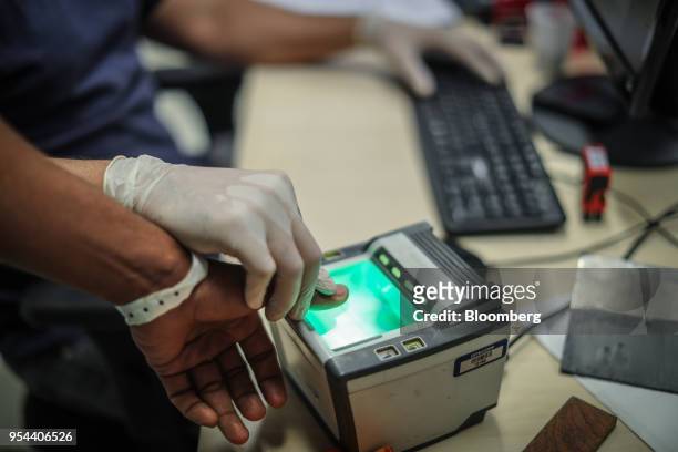 Venezuelan migrant is fingerprinted during registration at the federal police headquarters in Boa Vista, Rondonia state, Brazil, on Thursday, May 3,...