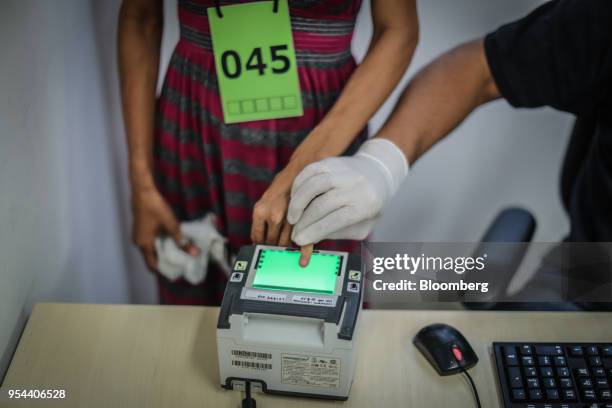 Venezuelan migrant is fingerprinted during registration at the federal police headquarters in Boa Vista, Rondonia state, Brazil, on Thursday, May 3,...