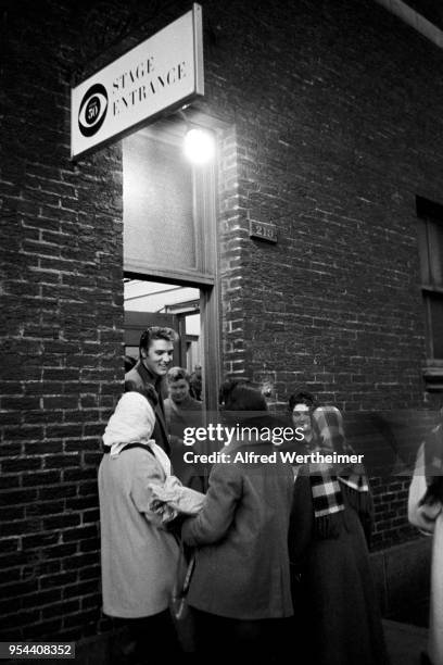 Alfred Wertheimer/MUUS Collection via Getty Images) American musician Elvis Presley signs autographs for fans at the CBS-TV Studio 50 stage door, New...