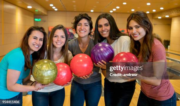 happy group of female friends having fun bowling looking at camera smiling - bowling woman stock pictures, royalty-free photos & images