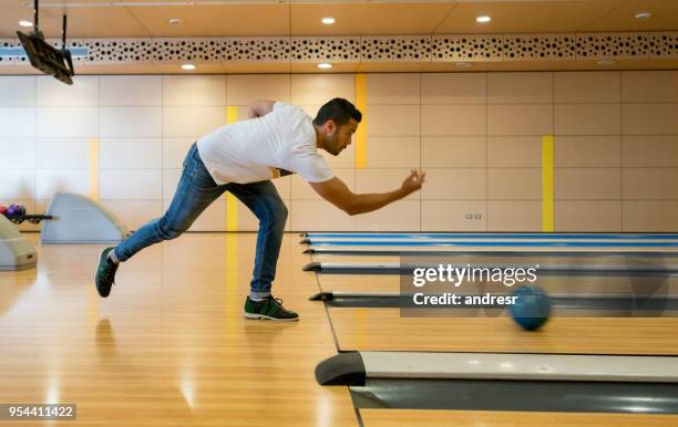 young male throwing the bowling ball looking very focused - man holding bowling ball stock pictures, royalty-free photos & images