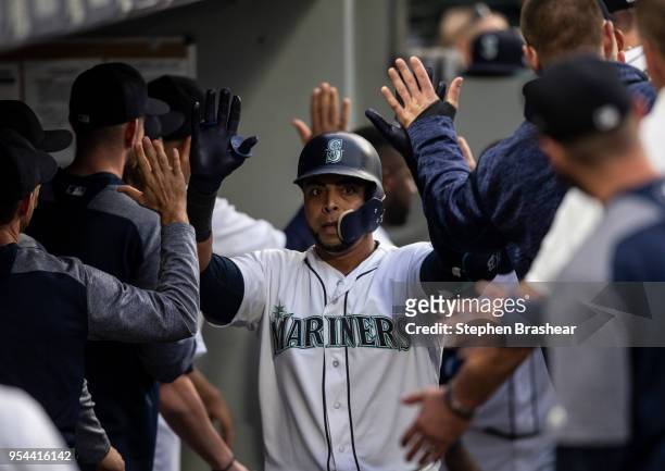 Nelson Cruz of the Seattle Mariners is congratulated by teammates after hitting a two-run home run off of starting pitcher Sean Manaea of the Oakland...