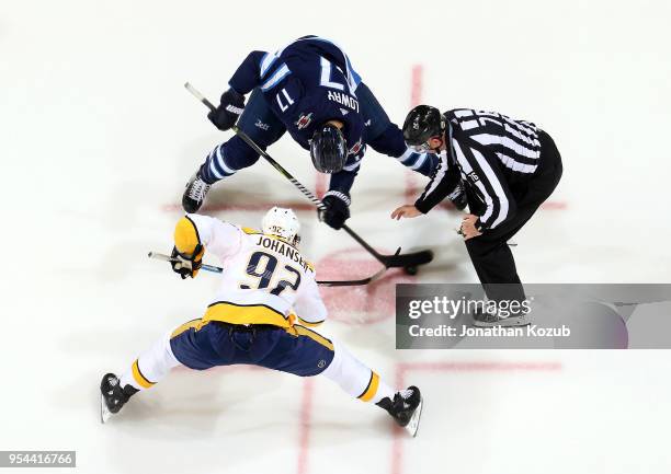 Adam Lowry of the Winnipeg Jets takes a second period face-off against Ryan Johansen of the Nashville Predators in Game Four of the Western...