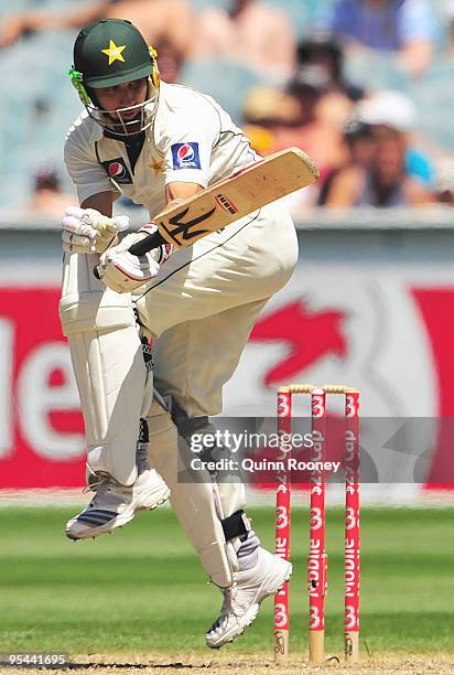 Saeed Ajmal of Pakistan tries to fend off a high pitched delivery during day three of the First Test match between Australia and Pakistan at...