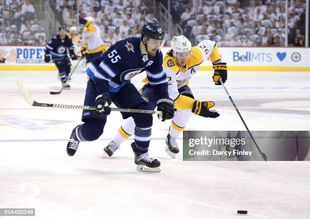 Mark Scheifele of the Winnipeg Jets and Ryan Johansen of the Nashville Predators chase the loose puck down the ice during second period action in...