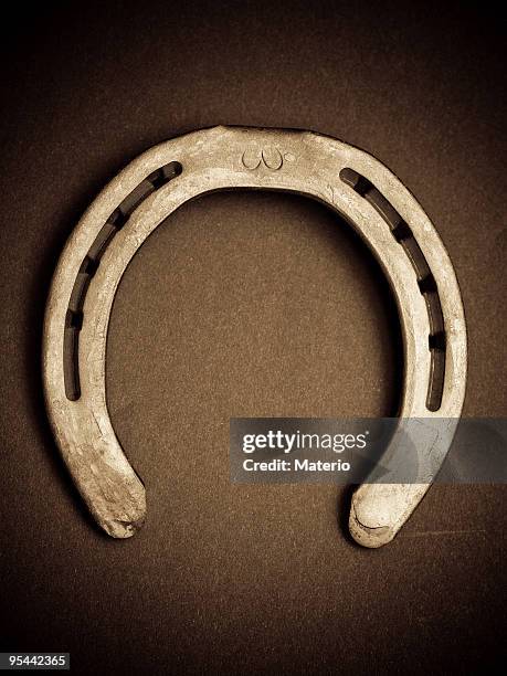 a used horseshoe with eight holes - hoefijzer stockfoto's en -beelden