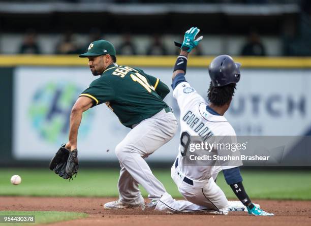 Dee Gordon of the Seattle Mariners steals second base before shortstop Marcus Semien of the Oakland Athletics can make a tag during the first inning...