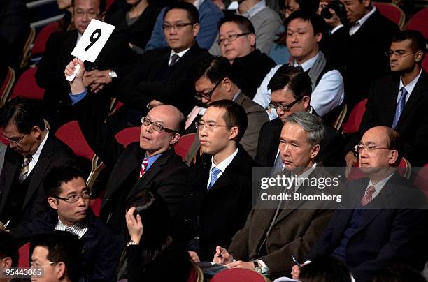 An unidentified bidder raises his paddle during an auction for one of two residential plots being sold by the government in Hong Kong, China, on...