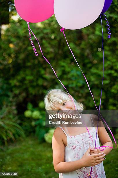 blonde girl holding helium balloons, smiling - wonky fringe stock pictures, royalty-free photos & images