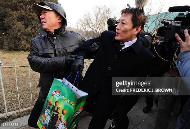 Shang Baojun , the lawyer for leading Chinese dissident Liu Xiaobao, is manhandled by plainclothes security personnel trying to keep him away from...