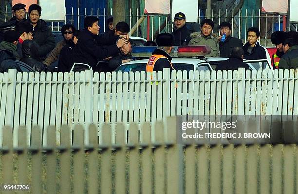 Protester is manhandled into a police vehicle during the trial of leading Chinese dissident Liu Xiaobao on subversion charges on December 23, 2009 in...