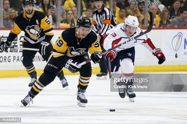 Jake Guentzel of the Pittsburgh Penguins and Nicklas Backstrom of the Washington Capitals chase after the puck in Game Three of the Eastern...