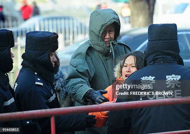 Police and plainclothed security personnel attempt to force a protester away from journalists outside the courthouse following the verdict for the...