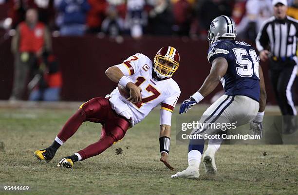 Jason Campbell of the Washington Redskins slides to avoid being hit by Bradie James of the Dallas Cowboys at Fedex Field on December 27, 2009 in...