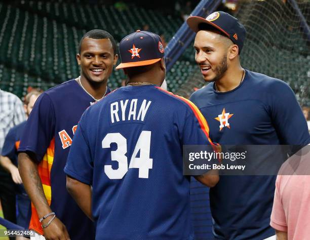 DeShaun Watson of the Houston Texans visits Carlos Correa during batting practice at Minute Maid Park on May 1, 2018 in Houston, Texas.