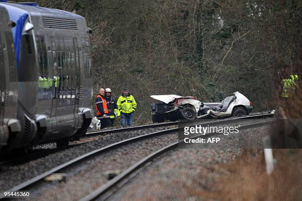 Des pompiers et des gendarmes s'activent autour d'une voiture écrasée après être entrée en colision avec un TER, le 22 décembre 2009 à...