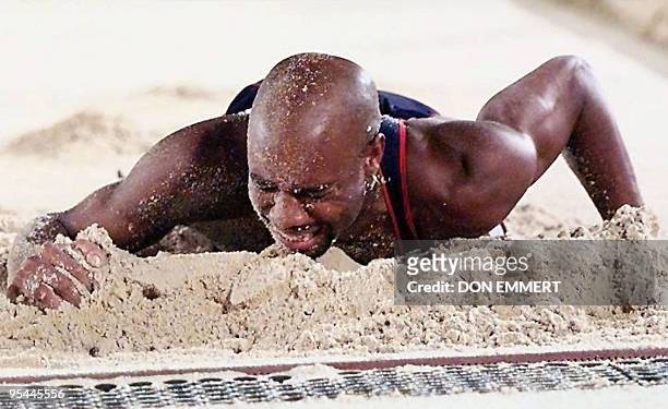 Mike Powell of the US lays in the pit after injuring his leg in the last attempt of the men's Olympic long jump event at the Olympic Stadium in...