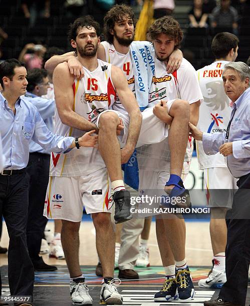 Spanish basketball player Pau Gasol is lifted by his teammates, Jorge Garbajosa and Marc Gasol , as they leave the court after their victory over...