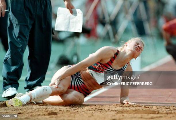 Russia's Anna Biryukova grimaces in pain after she fell during her first attempt in women's triple jump competition at the Athens '97 World...