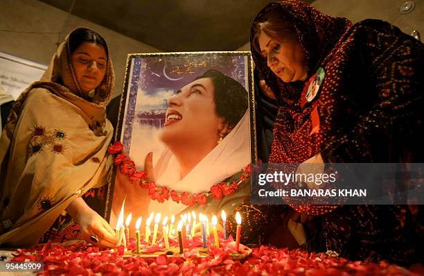 Supporters light candles in front of a picture of slain former Pakistan premier Benazir Bhutto on her second death anniversary in Quetta on December...