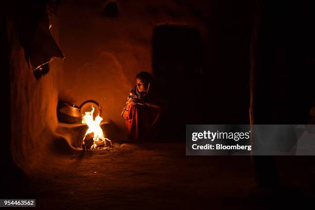 Woman cooks food by fire inside a home in Kraska village, Rajasthan, India, on Monday, April 16, 2018. The Indian government is trying to relocate...