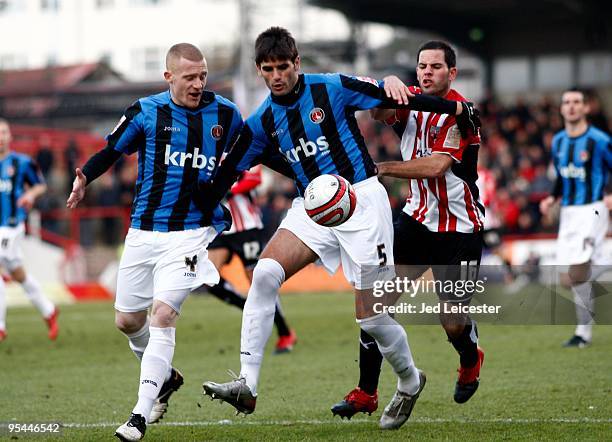 Nicky Bailey and Miguel Llera of Charlton Athletic combine to hold off Sam Wood of Brentford during the Coca Cola League One match between Brentford...