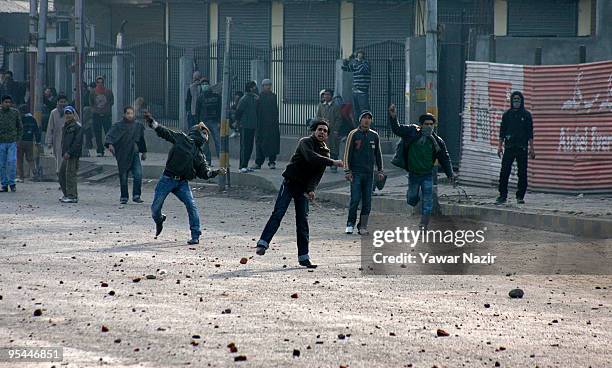Kashmiri Sunni Muslim protesters throw stones towards Indian police during a protest against ban on Ashura in Srinagar, India on December 28, 2009....