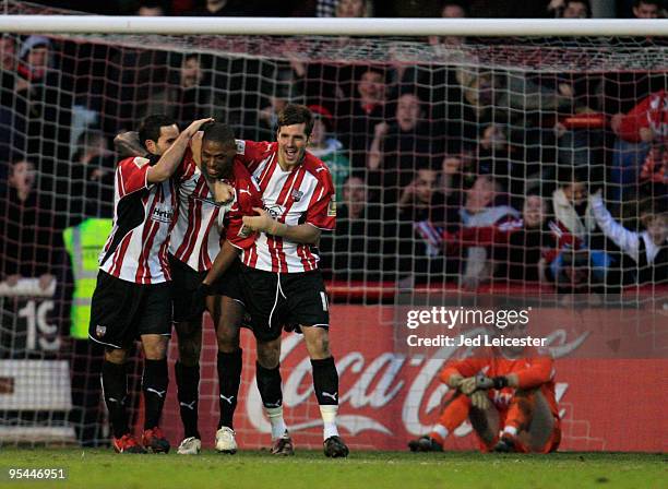 After scoring the opening goal, Carl Cort of Brentford celebrates with his team mates infront of a dejected Charlton Athletic goalkeeper Rob Elliot...