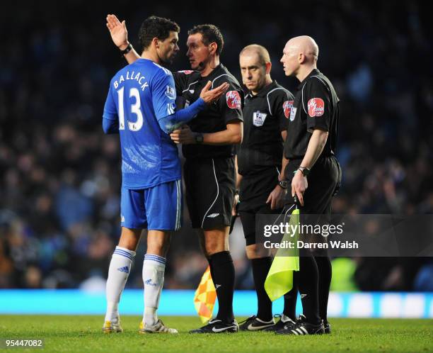 Michael Ballack of Chelsea talks to referee Andre Marriner and assistant referees Paddy Keane and Adam Watts during the Barclays Premier League match...