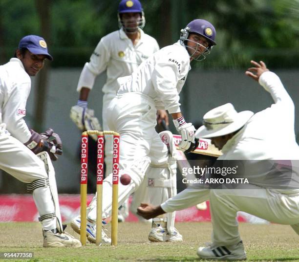 Sri Lankan fielder Mahela Jayawardana unsuccesfully tries to catch out Indian batsman Rahul Dravid as Sri Lankan wicketkeeper Kumar Sangakkara and...