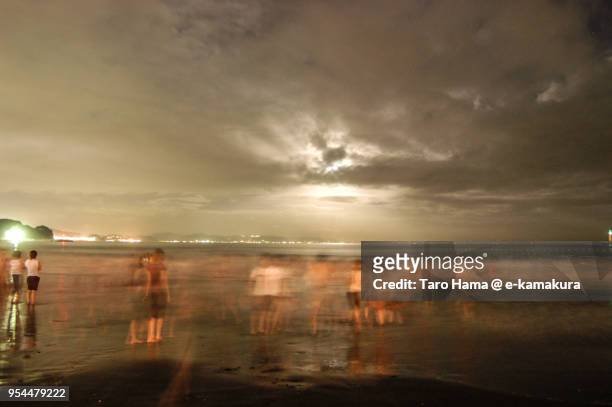 People playing on the night beach after the fireworks festival in Enoshima Island in Japan