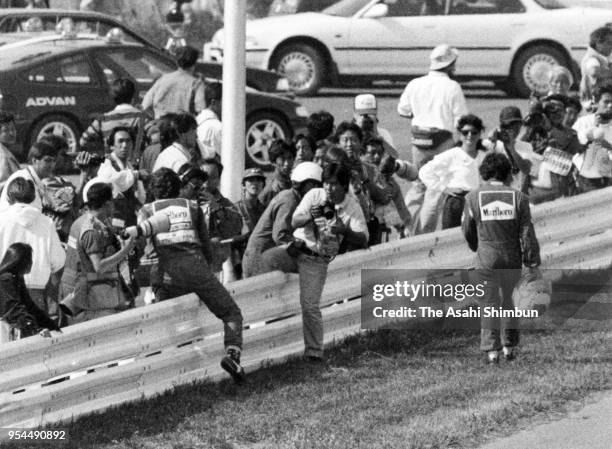 Alain Prost of France and Ferrari and Ayrton Senna of Brazil and McLaren-Honda return to the pit after their collision during the Formula One...