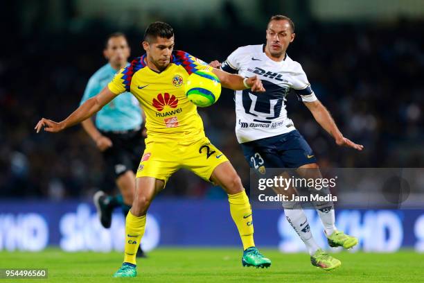 Henry Martin of America and Marcelo Diaz of Pumas compete for the ball during the quarter finals first leg match between Pumas UNAM and America as...