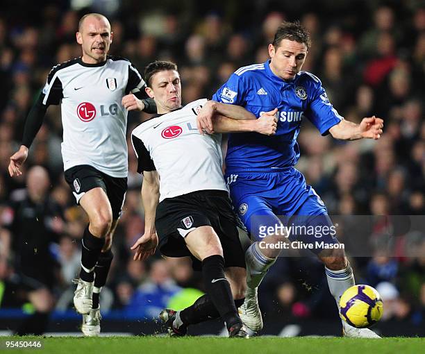 Frank Lampard of Chelsea takes on Chris Baird and Danny Murphy of Fulham during the Barclays Premier League match between Chelsea and Fulham at...