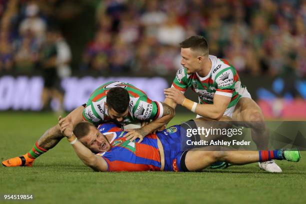 Nathan Ross of the Knights is tackled by the Rabbitohs defence during the round nine NRL match between the Newcastle Knights and the South Sydney...