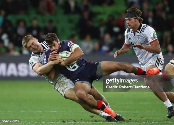 Tom English of the Rebels is challenged by Jack Goodhue of the Crusaders during the round 12 Super Rugby match between the Rebels and the Crusaders...