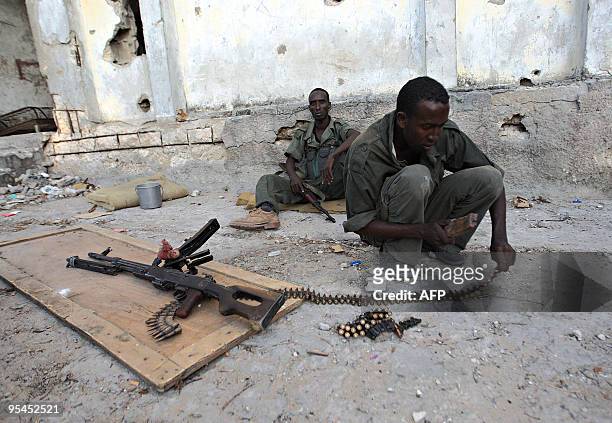 Government soldier loads bullets to a chain attached to his machine gun as government soldiers engage in a shootout with hard-line Islamic fighters...