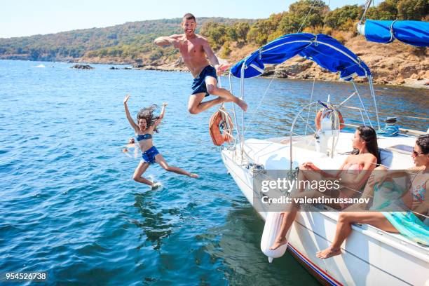 jeunes gens sautant d’yacht - jumping of boat photos et images de collection