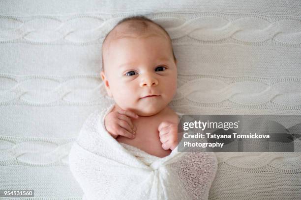 newborn baby boy in white wrap, looking curiously at camera - family photo shoot stock pictures, royalty-free photos & images