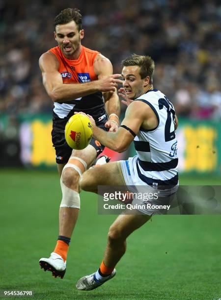 Jeremy Finlayson of the Giants and Cory Gregson of the Cats compete for the ball during the round seven AFL match between the Geelong Cats and the...