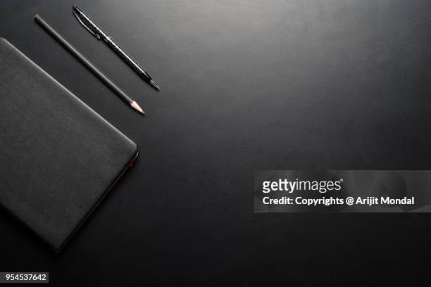 office desk table with note pad, pen, pencil on black background, top view with copy space - notepad table stock pictures, royalty-free photos & images