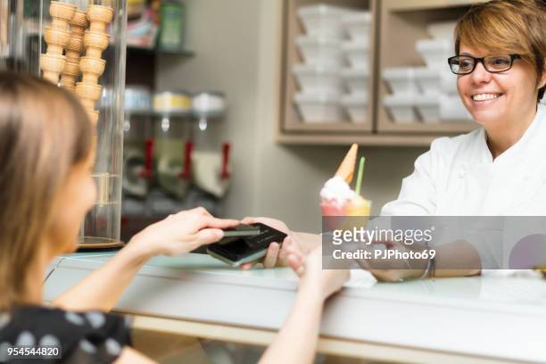 women use contactless payment in an ice cream shop - pjphoto69 stock pictures, royalty-free photos & images