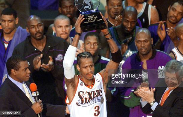 Philadelphia 76ers' guard Allen Iverson stands among his fellow NBA All-Stars and holds his MVP trophy for his performance in the 2001 NBA All-Star...