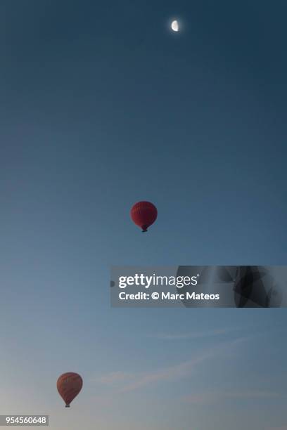 two hot-air balloons rising up to the decrescent moon - marc mateos stock pictures, royalty-free photos & images