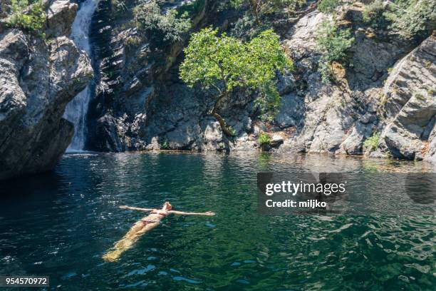 woman relaxing while floating on water - miljko stock pictures, royalty-free photos & images