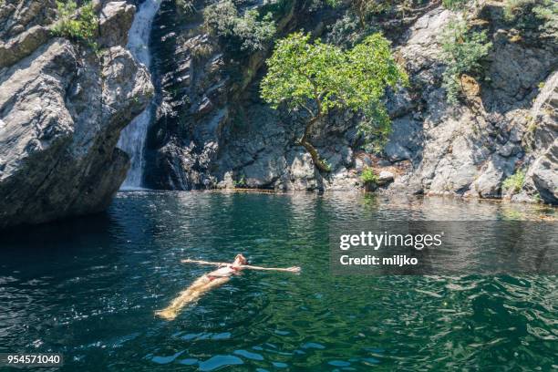 woman relaxing while floating on water - miljko stock pictures, royalty-free photos & images