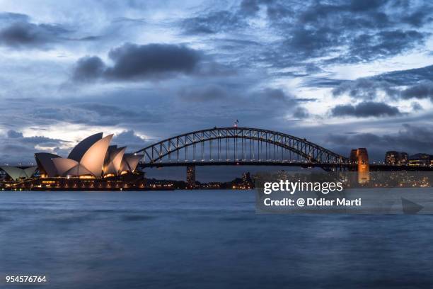 stunning twilight over the famous sydney opera house and the harbour bridge - oper von sydney stock-fotos und bilder