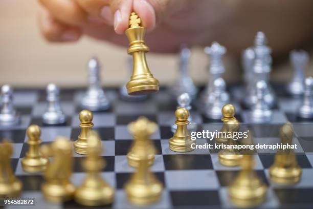 hand of businessman playing chess. - chess king piece stock pictures, royalty-free photos & images